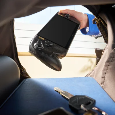 Main sortant la console portable ASUS ROG Ally X20 noire d'un sac, montrant sa conception compacte pour joueurs nomades.