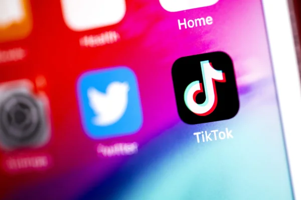 Vue de près d'un écran de smartphone affichant les icônes des applications TikTok et Twitter côte à côte, illustrant la dominance de TikTok parmi les jeunes utilisateurs américains.