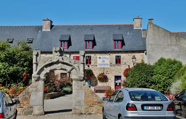 Façade de l'Office de Tourisme de Pleubian, bâtiment en pierre avec une voûte en arcade et des voitures garées de chaque côté.