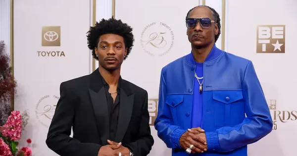 Snoop Dogg et un autre homme sur le tapis rouge des BET Awards, avec des logos Toyota en arrière-plan, pour l'annonce de la date de sortie de son biopic.