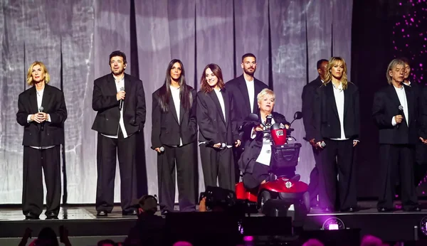 Mimi Mathy en fauteuil roulant sur scène lors du concert des Enfoirés