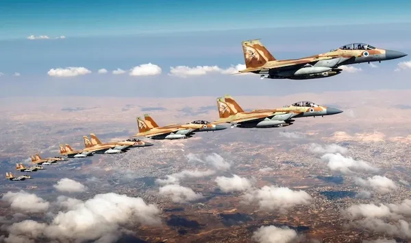 Formation de huit avions de chasse de l'armée de l'air israélienne au camouflage désert volant en formation en échelon au-dessus d'un paysage nuageux lors de l'opération Rising Lion