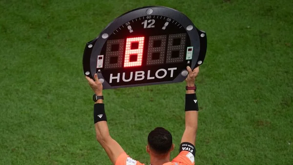 Un quatrième arbitre tient un panneau électronique Hublot affichant le numéro 8 pour un remplacement lors d'un match de football, illustrant les nouvelles règles attendues en Premier League anglaise cette saison