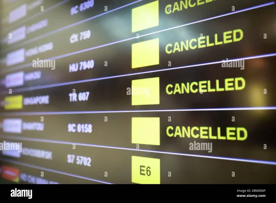 Gros plan en angle sur un tableau d'affichage des vols d'aéroport où plusieurs vols sont indiqués 'CANCELLED' en lettres jaunes lumineuses, avec numéros de vol et destinations, et indication de porte E6 visible en bas