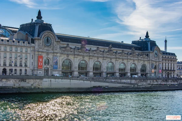 Le Musée d'Orsay, majestueux bâtiment Beaux-Arts au bord de la Seine à Paris, avec la tour Eiffel visible au loin, illustrant les musées gratuits pour les moins de 26 ans