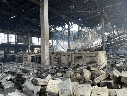 Intérieur ravagé de l'entrepôt humanitaire de la Croix-Rouge ukrainienne à Kyiv, toit effondré, débris calcinés jonchant le sol et appareils électroménagers brûlés entassés après l'attaque massive