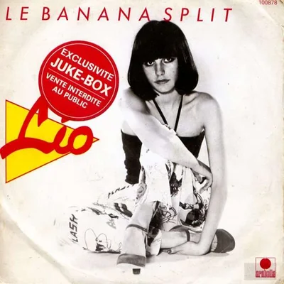 Affiche promotionnelle vintage du 45 tours « Le Banana Split » de Lio, présentant une photographie en noir et blanc de la chanteuse assise au sol avec un carré sombre et un maquillage prononcé des yeux