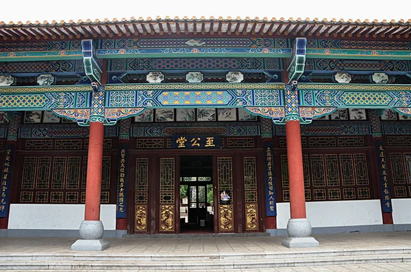 Façade de l'ancien bâtiment de l'Université nationale associée du Sud-Ouest (Lianda) à Kunming, avec avant-toits peints en bleu et vert, colonnes rouges et enseigne « Zhigongtang ».