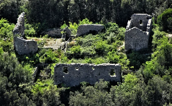 Ruines en pierre de la chapelle de la Magdeleine, ancien ermitage médiéval isolé dans la végétation ardéchoise avec murs écroulés et vestiges envahis par la nature