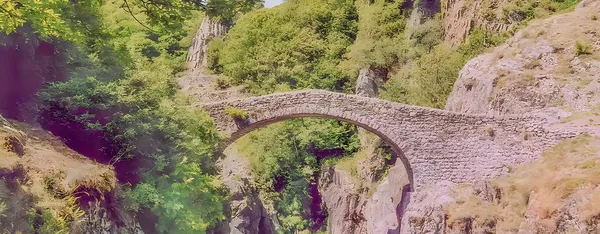 Le Pont du Diable de Thueyts, arche naturelle de basalte enjambant la rivière Ardèche au cœur d'un paysage volcanique et boisé
