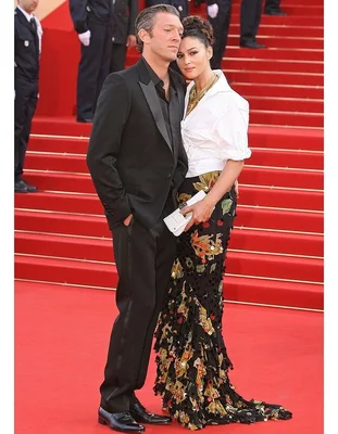 Monica Bellucci en haut blanc et jupe fleurie et Vincent Cassel en costume noir posant sur le tapis rouge du Festival de Cannes, lors de la présentation du film Indigènes.