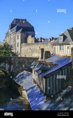 Photographie du lavoir historique de Vannes en Bretagne, montrant son bassin en pierre et sa charpente en bois traditionnelle sous une toiture en ardoise au bord de l'eau
