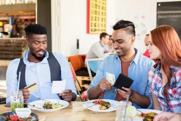 Groupe d'amis heureux réglant ensemble l'addition au restaurant, paiement avec carte bancaire dans une ambiance conviviale et détendue