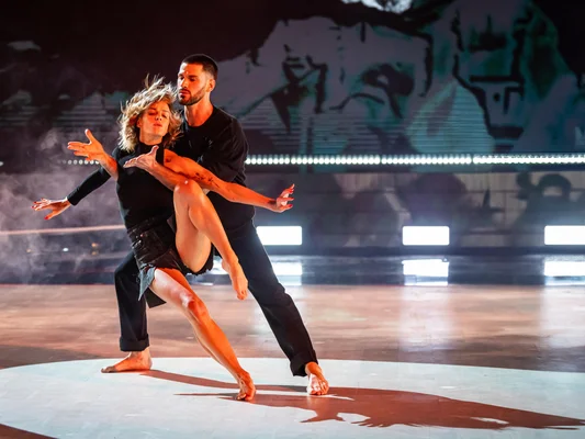 Fauve Hautot dansant avec un partenaire masculin sur scène lors de l'émission 'Danse avec les stars', effectuant une routine contemporaine où la femme est en équilibre sur une jambe soutenue par l'homme.