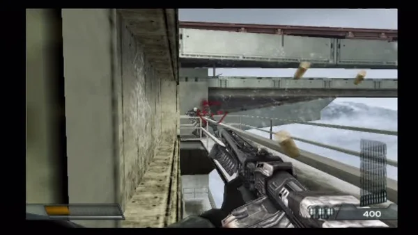 Capture d'écran de gameplay de Killzone sur PlayStation 2 montrant le joueur tenant une arme futuriste sur une passerelle industrielle avec des douilles éjectées.