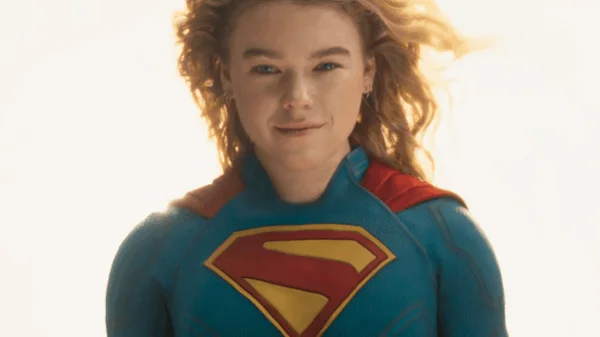 Milly Alcock en tant que Supergirl dans la bande-annonce du film, portant un costume bleu avec le blason 'S' rouge et jaune sur la poitrine et une cape rouge.