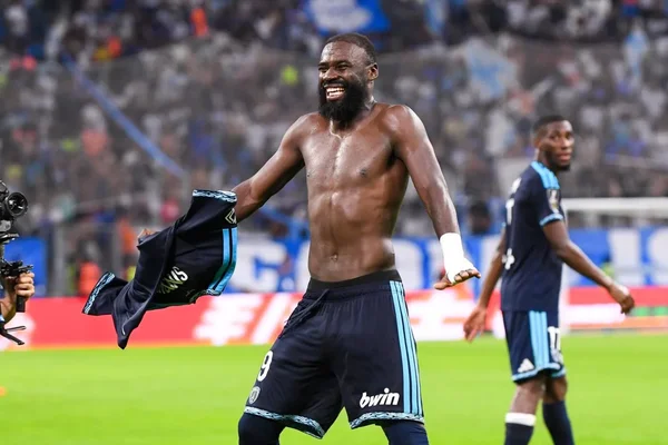 Un joueur du Paris FC, barbu et torse nu, célèbre en tenant son maillot après la victoire de son équipe face à l'OM lors d'un match de Ligue 1.