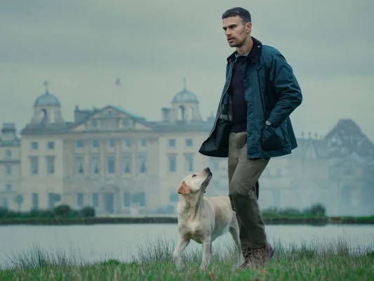 Theo James dans le rôle d'Eddie Horniman dans la série Netflix 'The Gentlemen', en costume élégant pour une scène promotionnelle.