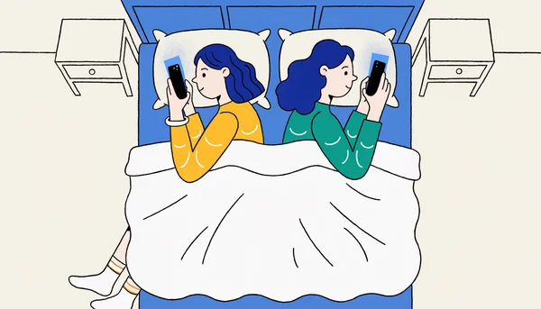 Un couple allongé côte à côte dans un lit la nuit, chacun regardant son smartphone avec une lueur bleue sur le visage, illustrant la déconnection émotionnelle malgré la proximité physique.