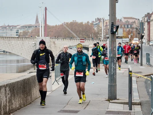Scène de la Lyon Urban Trail montrant une foule de coureurs traversant les rues de la ville lors de la 14e édition