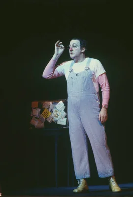 Le comédien Coluche sur scène au Théâtre du Gymnase à Paris en décembre 1980, capturé en plein numéro d'humour.