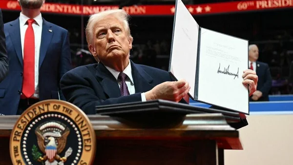 Donald Trump, président des États-Unis, tenant une lettre adressée à l'ONU confirmant le retrait américain de l'accord de Paris sur le climat, le 20 janvier 2025.