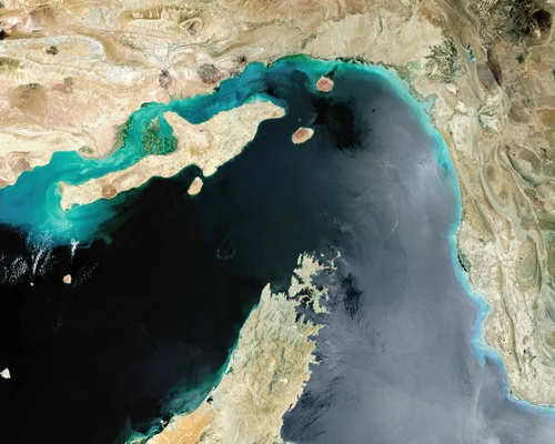 Image satellite du détroit d'Ormuz, point de passage maritime stratégique, avec la péninsule de Musandam et les Émirats arabes unis au premier plan et la côte iranienne en arrière-plan.