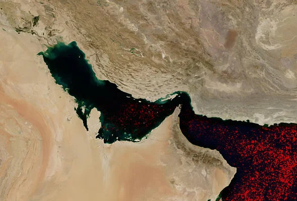 Image satellite du détroit d'Ormuz montrant une prolifération d'algues rougeâtres, utilisée pour illustrer les perturbations du trafic maritime et les routes des pétroliers du Golfe lors de la crise de 2026.