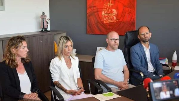 Emilie Schipper et Jérôme Legobien-Cadillac, parents d'Angela, au centre, entourés de leurs avocats Me Elsa Cazor et Me Cédric Galandrin lors d'une conférence de presse, assis à une table avec des micros et une caméra au premier plan.