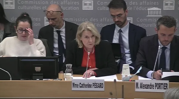Réunion de la commission des affaires culturelles et de l'éducation de l'Assemblée nationale autour d'une table, avec des plaques nominatives identifiant Mme Catherine Pégard et M. Alexandre Portier, en arrière-plan le logo de la commission.
