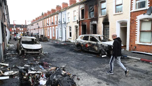 Scène d'émeutes anti-immigrés à Belfast illustrant le lourd héritage des violences sectaires en Irlande du Nord