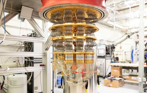 Cryostat doré de la technologie d'informatique quantique de Google, avec étages plaqués or, nombreux câbles et câblages suspendus dans un laboratoire