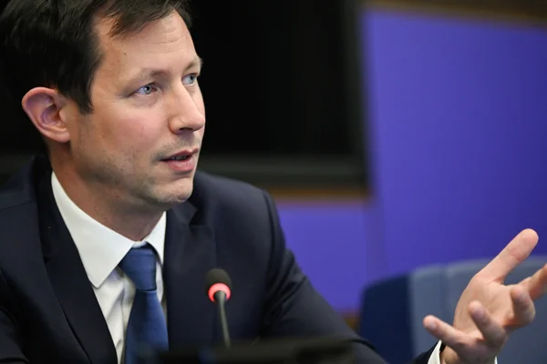 François-Xavier Bellamy en costume sombre, chemise blanche et cravate bleue, s'exprimant au micro avec un geste de la main lors d'une intervention formelle