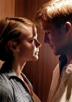 Ryan Gosling et Carey Mulligan dans Drive, en gros plan de profil face à face presque nez à nez sous une lumière chaude sur fond boisé, elle en chemise à carreaux, lui en veste claire