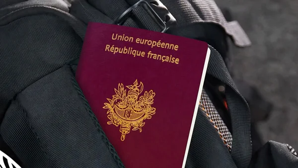 Passeport français posé sur un sac à dos noir, illustrant un refus d'embarquement lié à un passeport périmé