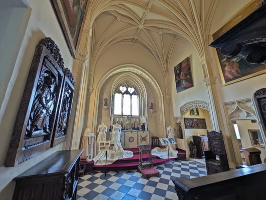 Chapelle gothique du château de Brissac avec voûtes d'ogives, sol en damier noir et blanc et tableaux religieux