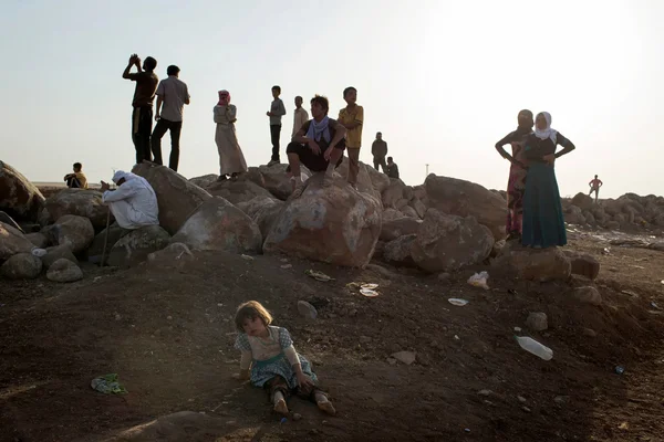 Familles yézidies descendant d'une montagne irakienne à la recherche de proches disparus en août 2014