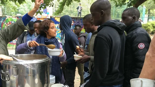Bénévoles distribuant des repas chauds et apportant du réconfort à des migrants mineurs à la rue à Paris
