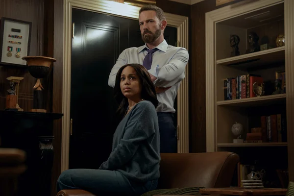Photo officielle du film Animals : Ben Affleck, bras croisés, debout derrière Kerry Washington, assise sur un canapé en cuir dans une pièce lambrissée.