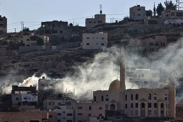 Fumée s'élevant après une explosion lors de combats entre les forces de sécurité de l'Autorité palestinienne et des militants à Jénine, sur une colline bâtie avec des immeubles et une mosquée