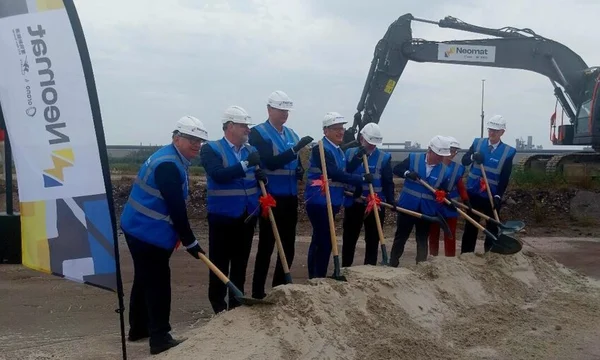 Des élus et ministres, casqués et vêtus de gilets de sécurité, participent à une pelletée de sable lors d'une cérémonie de lancement, avec une pelleteuse en arrière-plan.