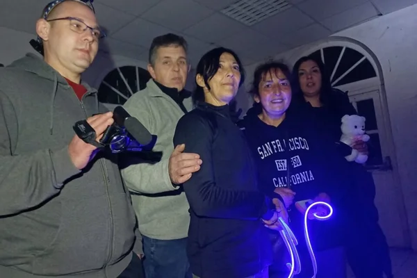 Groupe de cinq chasseurs de fantômes lors d'une enquête paranormale nocturne dans un internat désaffecté, l'un tenant une caméra et un autre un bâton lumineux bleu