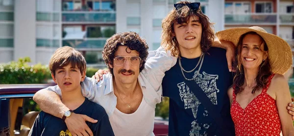 Photographie promotionnelle du film Juste une illusion de Toledano et Nakache : quatre personnages, probablement une famille, posant devant un bâtiment