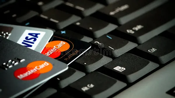 Trois cartes de crédit Visa et Mastercard posées sur un clavier d'ordinateur noir, illustrant la notion de fuite de données bancaires