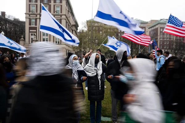Des étudiants forment une barrière humaine devant des étudiants pro-israéliens pour protéger une bandière pro-palestinienne lors de manifestations à l'université Columbia, le 18 avril 2024