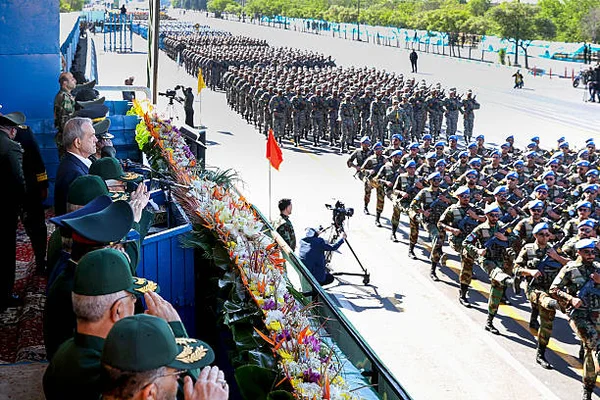 Défilé militaire iranien à Téhéran à l'occasion de la Journée des forces armées, des soldats marchant en formation devant une tribune officielle