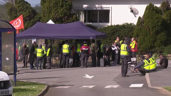 Salariés de l'usine Arquus de Saint-Nazaire en gilets jaunes réunis sous une tente violette devant leur site pour manifester contre la chute des commandes militaires, le 2 avril 2026.