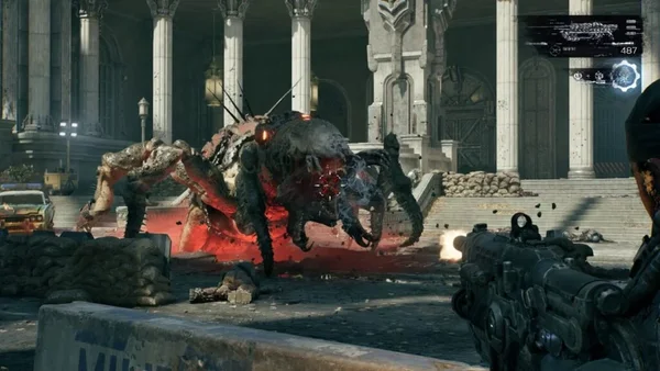 Capture d' gameplay de Gears of War: E-Day montrant Marcus en train de tirer avec une arme massive sur un monstre araignée muté dans une place urbaine en ruines