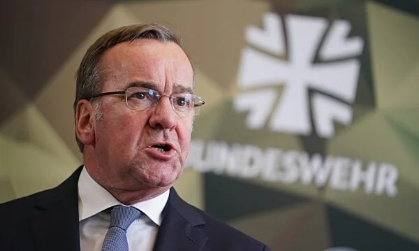 Boris Pistorius, ministre fédéral allemand de la Défense, en costume sombre et cravate bleue, prenant la parole devant un logo de la Bundeswehr