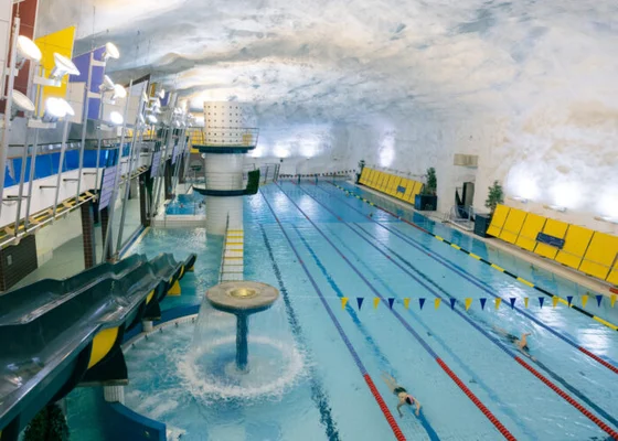 Piscine couverte avec couloirs de nage et toboggans installée dans une grotte souterraine à Helsinki, illustrant les usages multiples des espaces souterrains finlandais